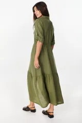 Vestido camisero largo de lino italiano color celeste, de corte relajado, con mangas caídas, jareta ajustable en la cintura, cierre frontal de botones y bajo con volado fruncido.
