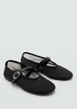 Zapato tipo bailarina de malla negra con cierre de hebilla y cinta decorativa, de punta redonda y suela plana.