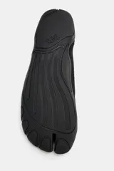 Bailarina deportiva color negro con diseño de puntera dividida, doble tira elástica en el empeine y tirador trasero. Suela plana de goma con relieve.