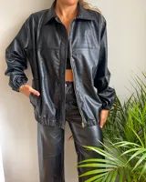 Campera negra de cuero sintético con textura crocco, cierre frontal con cremallera y cuello camisero.