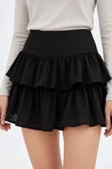 Minifalda blanca de viscosa con diseño de doble vuelo y volados horizontales.