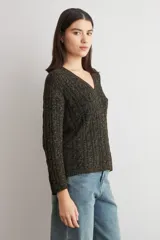 Sweater de tejido de punto con textura acanalada, color verde oscuro, de corte recto y manga larga. Presenta un diseño clásico con cuello redondo.