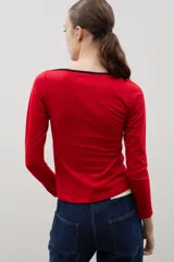 Remera de algodón color rojo con escote bote y detalle de borde en color negro. De manga larga y corte ajustado al cuerpo.