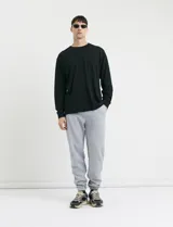 Pantalón jogging de tejido circular con cintura elástica y cordón ajustable. Presenta puños elastizados en el ruedo y bolsillos laterales.