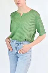 Remera de punto acanalado en color verde, con cuello polo y mangas cortas.