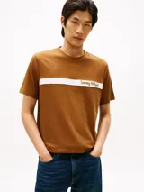Remera de manga corta Tommy Hilfiger color marrón, con cuello redondo y una franja horizontal blanca en el pecho que incluye el logo de la marca estampado.
