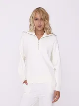 Sweater blanco de tejido de punto, con cuello alto con cierre metálico y mangas largas.