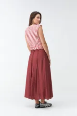Falda larga beige de corte evasé, con diseño fluido y detalles de costuras verticales en la parte delantera.