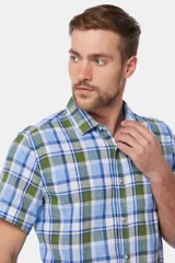 Camisa de lino de manga corta con diseño a cuadros en tonos azul, verde y blanco, con cuello camisero y cierre frontal de botones.