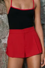 Shorts de tiro medio con bolsillos laterales y detalle de pinzas delanteras. Cierre frontal con cremallera, botón interior y gancho metálico.