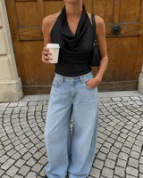Top negro de satén con escote halter y cuello drapeado, sin mangas y diseño ajustado.