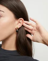 Par de aros colgantes con gancho, de metal dorado y dije redondo de murano negro.