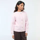 Cárdigan de punto color rosa, con cuello redondo, cierre frontal de botones dorados y puños acanalados.