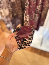 Camisa de manga larga con estampado animal print y detalles de encaje en el frente. Presenta un cuello con lazo integrado y un diseño fluido y elegante.