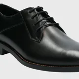 Zapato de vestir formal Hush Puppies modelo Blues, confeccionado en cuero negro con cierre de cordones. Presenta una silueta clásica con puntera redondeada y suela de goma resistente.