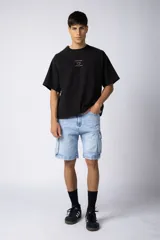 Bermuda cargo de jean con bolsillos laterales XL y efecto de lavado gastado. Presenta un corte cómodo y resistente, ideal para uso diario.