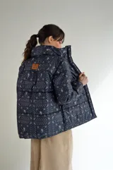 Campera puffer de corte holgado con cuello alto, confeccionada con tejido estampado estilo bandana. Presenta diseño capitoneado, cierre frontal y etiqueta de marca en la parte superior trasera.
