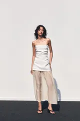 Vestido midi de escote palabra de honor con cuerpo drapeado y falda de tejido combinado con caída fluida. Presenta cierre con cremallera oculta.