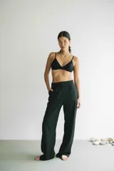 Top de bikini negro, de corte triangular clásico, con copas removibles y tirantes finos. Confeccionado en tejido italiano con filtro UV 50.