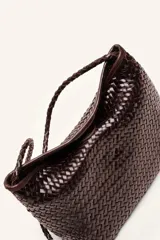 Cartera tipo morral y bandolera de cuero vacuno marrón, completamente trenzada a mano con diseño estructurado y correa larga trenzada.
