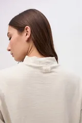 Remera de manga larga con cuello polera, confeccionada en tela texturizada con calce relajado.