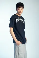 Bermuda deportiva de felpa color negro, de corte ancho y largo por debajo de las rodillas, con cintura elástica.