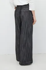 Pantalón de jean azul oscuro de tiro alto, con diseño holgado de pierna ancha, pinzas en la cintura y costuras a la vista.