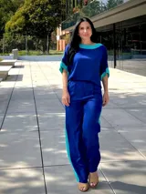 Blusa azul de manga corta con cuello redondo y detalles en turquesa en el cuello y las mangas.