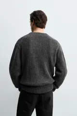 Jersey de corte relajado confeccionado en una mezcla de algodón y lana. Presenta cuello redondo, manga larga y acabados en rib en puños y bajo.