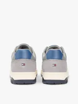 Zapatillas de baloncesto Tommy Hilfiger de corte bajo, color blanco con detalles en gris, azul y suela bitonal. Presentan exterior de piel con paneles de ante y mezcla de texturas, cordones blancos y detalles distintivos de la marca.