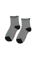 Medias de caña corta color blanco con estampado de lunares negros y borde superior con detalle de volados.