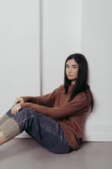 Sweater de punto con textura de ochos verticales, cuello redondo, mangas largas con puños acanalados y silueta relajada.