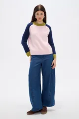 Sweater de punto con diseño color block, presenta cuerpo en color rosado, mangas en azul marino y detalles de cuello y puños en color verde oliva. Posee un corte holgado y cuello redondo a la base.