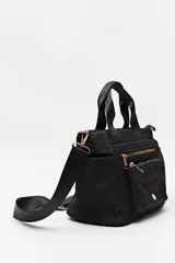 Cartera negra de nylon con diseño compacto y funcional. Cuenta con asas cortas y correa regulable desmontable para llevar al hombro o cruzada, además de múltiples bolsillos con cierre y detalles dorados.