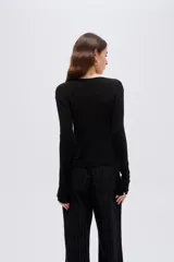 Top de manga larga en tejido de punto con lurex, color negro, de corte ajustado al cuerpo, con escote en V pronunciado y cierre delantero mediante finos lazos para anudar.