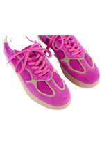 Championes urbanos de cuero y gamuza en color fucsia, con detalles en verde oliva, cordones fucsias y suela de goma marrón clara.