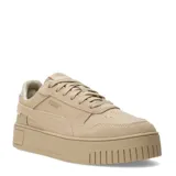 Championes Puma modelo Carina Street SD, con diseño de plataforma y empeine que combina cuero y gamuza en tono beige. Presentan perforaciones decorativas en la puntera, cierre con cordones y suela de plataforma robusta con logo grabado en el talón.