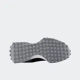 Championes New Balance modelo 327, con capellada en tonos gris oscuro y marrón, logo 'N' lateral en blanco y entresuela blanca. Suela exterior de goma con tacos prominentes.