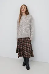 Buzo de tejido de punto en color marrón con un patrón ornamental floral en color celeste. Presenta cuello redondo, mangas largas y un corte holgado.