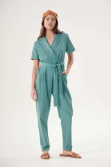 Mono largo color verde azulado, con cuello camisero, mangas cortas, corte cruzado con lazo en la cintura y bolsillos laterales.