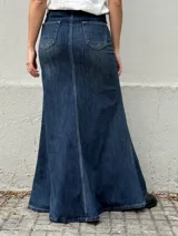 Pollera larga de denim con tiro alto, diseño ajustado en la parte superior y corte acampanado hacia el ruedo. Presenta costuras decorativas en diagonal que aportan movimiento y estructura a la prenda.