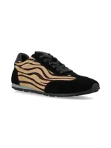 Championes urbanos con diseño combinado en gamuza negra y paneles laterales de pelo sintético con estampado animal print tipo cebra. Presentan cordones negros y suela plana de goma.
