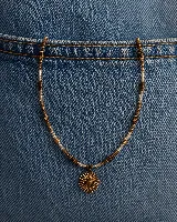 Collar de cuentas con dije central en forma de sol con piedra marrón en el centro. El diseño combina cuentas de madera marrón, cuentas metálicas doradas y cuentas de cristal transparente.
