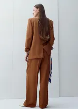 Pantalón de vestir de corte recto y tiro medio, color marrón, con pinzas frontales y bolsillos laterales.
