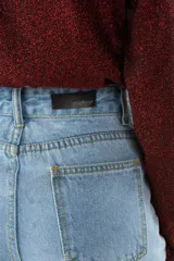 Remera de manga larga con cuello polera, confeccionada en tejido brillante con acabado metalizado en color bordó. Presenta un ajuste regular.