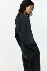 Remera de punto fino color gris oscuro, con escote en V y mangas dolman largas.