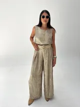 Conjunto de musculosa y pantalón palazzo color dorado brillante. La musculosa es sin mangas y el pantalón es de corte ancho con cintura alta.