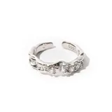 Anillo plateado ajustable con cinco circonias engarzadas.