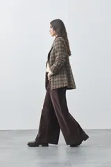 Pantalón de pana de corte wide leg, color marrón oscuro, con calce relajado y detalle de bordado en el borde de los bolsillos delanteros.