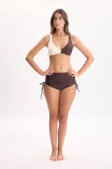 Bombacha de bikini tiro alto color marrón, con jaretas laterales ajustables que permiten regular el frunce.